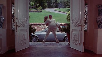 Movie still from “The Man with Two Brains” (1983), directed by Carl Reiner – A man and a woman are kissing in front of a car; Wide shot, Low angle