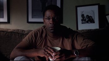 Movie still from “The Manchurian Candidate” (2004), directed by Jonathan Demme – A man sitting on a couch holding a coffee cup; Close Up shot, Low angle
