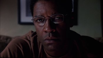 Movie still from “The Manchurian Candidate” (2004), directed by Jonathan Demme – A person wearing glasses and a brown shirt; Close Up shot, Over the shoulder angle