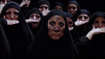 Movie still from “The Manchurian Candidate” (2004), directed by Jonathan Demme – A group of women in black dresses with faces painted with tattoos; Close Up shot, Overhead angle