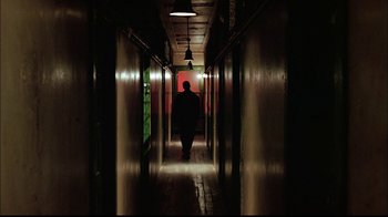 Movie still from “The Manchurian Candidate” (2004), directed by Jonathan Demme – A person walking down a long hallway in a building; Wide shot, Low angle