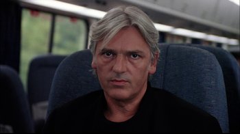 Movie still from “The Manchurian Candidate” (2004), directed by Jonathan Demme – A person sitting on a train; Close Up shot, Low angle