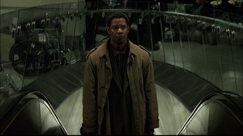 Movie still from “The Manchurian Candidate” (2004), directed by Jonathan Demme – A man standing on top of an escalator in a building; Medium shot, Low angle