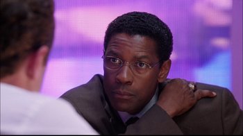 Movie still from “The Manchurian Candidate” (2004), directed by Jonathan Demme – A person wearing a suit and glasses; Close Up shot, Over the shoulder angle