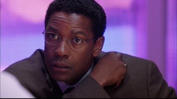 Movie still from “The Manchurian Candidate” (2004), directed by Jonathan Demme – A person wearing a suit and glasses; Close Up shot, Over the shoulder angle