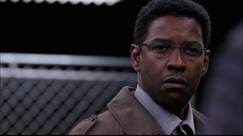 Movie still from “The Manchurian Candidate” (2004), directed by Jonathan Demme – A person wearing glasses and a jacket; Close Up shot, Over the shoulder angle