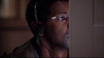 Movie still from “The Manchurian Candidate” (2004), directed by Jonathan Demme – A person wearing headphones and glasses; Close Up shot, Over the shoulder angle