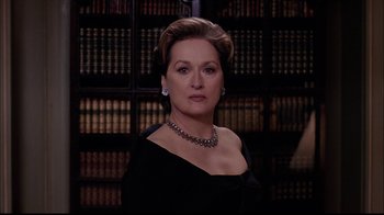 Movie still from “The Manchurian Candidate” (2004), directed by Jonathan Demme – A woman in a black dress in front of a book case; Close Up shot, Low angle