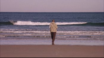 Movie still from “The Manchurian Candidate” (2004), directed by Jonathan Demme – A man walking on the beach near the ocean; Wide shot, Low angle