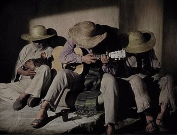 Movie still from “The Mark of Zorro” (1940), directed by Rouben Mamoulian – A group of men sitting on the ground playing guitars; Wide shot, High angle