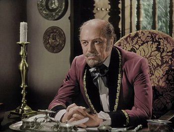 Movie still from “The Mark of Zorro” (1940), directed by Rouben Mamoulian – A man sitting at a table in a room; Medium shot, High angle