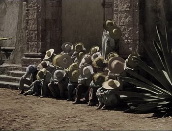 Movie still from “The Mark of Zorro” (1940), directed by Rouben Mamoulian – A group of people sitting next to each other on the ground; Wide shot, High angle
