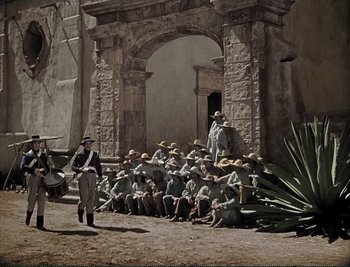 Movie still from “The Mark of Zorro” (1940), directed by Rouben Mamoulian – A group of men sitting in front of a stone arch; Wide shot, High angle