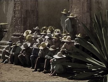 Movie still from “The Mark of Zorro” (1940), directed by Rouben Mamoulian – A group of men sitting next to each other wearing cowboy hats; Wide shot, High angle