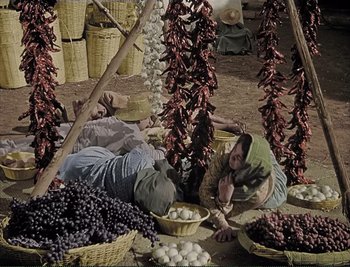 Movie still from “The Mark of Zorro” (1940), directed by Rouben Mamoulian – A man laying on the ground next to a pile of grapes; Wide shot, High angle
