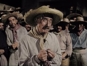 Movie still from “The Mark of Zorro” (1940), directed by Rouben Mamoulian – An old man wearing a straw hat and holding a whip; Medium shot, High angle