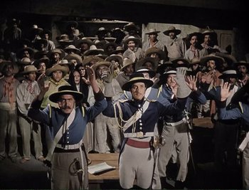 Movie still from “The Mark of Zorro” (1940), directed by Rouben Mamoulian – A group of men in uniforms and hats standing in front of a crowd; Wide shot, High angle