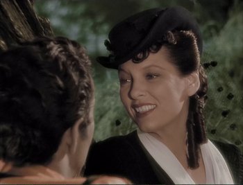 Movie still from “The Mark of Zorro” (1940), directed by Rouben Mamoulian – A woman wearing a black hat is smiling at another woman; Close Up shot, Over the shoulder angle