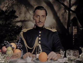 Movie still from “The Mark of Zorro” (1940), directed by Rouben Mamoulian – A man in a military uniform sitting at a dinner table; Medium shot, Low angle