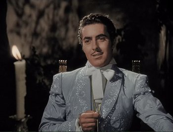 Movie still from “The Mark of Zorro” (1940), directed by Rouben Mamoulian – A man in a suit and tie holding a cane; Medium shot, Low angle