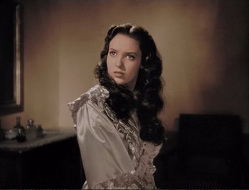 Movie still from “The Mark of Zorro” (1940), directed by Rouben Mamoulian – A woman with long black curly hair wearing a white dress; Close Up shot, Over the shoulder angle
