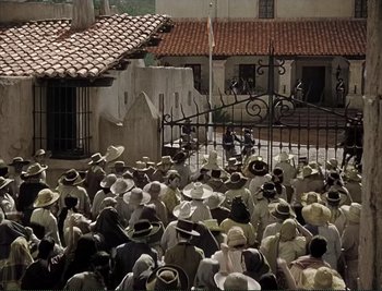 Movie still from “The Mark of Zorro” (1940), directed by Rouben Mamoulian – A group of people gathered in front of an iron gate; Extreme Wide shot, High angle