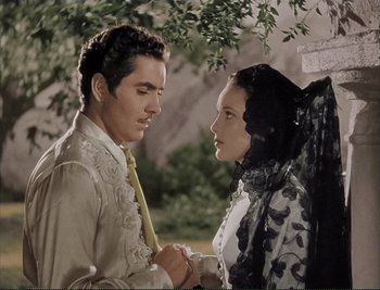 Movie still from “The Mark of Zorro” (1940), directed by Rouben Mamoulian – A man and a woman standing next to each other under a tree; Medium shot, Low angle
