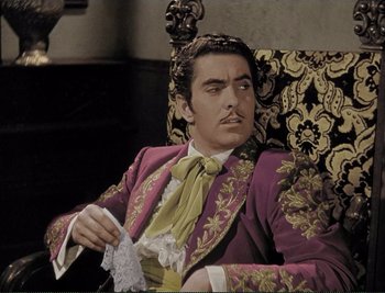 Movie still from “The Mark of Zorro” (1940), directed by Rouben Mamoulian – A man sitting in a chair wearing a suit and tie; Medium shot, Low angle