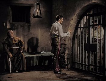 Movie still from “The Mark of Zorro” (1940), directed by Rouben Mamoulian – A man standing next to a woman in front of an iron gate; Wide shot, High angle