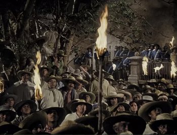 Movie still from “The Mark of Zorro” (1940), directed by Rouben Mamoulian – A group of people wearing sombreros and holding torches; Wide shot, High angle