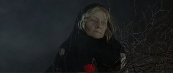 Movie still from “The Masque of the Red Death” (1964), directed by Roger Corman – An old woman wearing a black veil with a rose in it; Close Up shot, Low angle