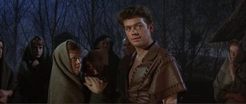 Movie still from “The Masque of the Red Death” (1964), directed by Roger Corman – A group of people standing in the dark; Medium shot, Over the shoulder angle