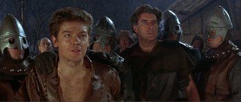 Movie still from “The Masque of the Red Death” (1964), directed by Roger Corman – A group of men in medieval garb in a dark room; Medium shot, Low angle