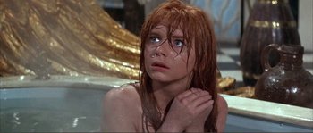 Movie still from “The Masque of the Red Death” (1964), directed by Roger Corman – A woman with red hair is sitting in a bath tub; Close Up shot, High angle