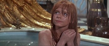 Movie still from “The Masque of the Red Death” (1964), directed by Roger Corman – A woman with wet red hair and blue eyes looking up; Close Up shot, High angle