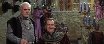 Movie still from “The Masque of the Red Death” (1964), directed by Roger Corman – A man sitting in a chair in front of candles; Medium shot, Low angle