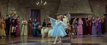 Movie still from “The Masque of the Red Death” (1964), directed by Roger Corman – A girl in a blue dress is dancing in front of a crowd; Wide shot, Low angle