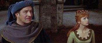 Movie still from “The Masque of the Red Death” (1964), directed by Roger Corman – A man and a woman dressed in medieval garb in front of a stone building; Medium shot, Over the shoulder angle