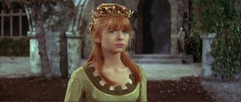 Movie still from “The Masque of the Red Death” (1964), directed by Roger Corman – A woman in a green dress with a crown on her head; Close Up shot, Low angle