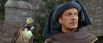 Movie still from “The Masque of the Red Death” (1964), directed by Roger Corman – A person wearing a hat with a bird in the background; Close Up shot, Low angle