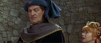 Movie still from “The Masque of the Red Death” (1964), directed by Roger Corman – A person wearing a hat and a cape; Medium shot, Low angle