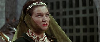 Movie still from “The Masque of the Red Death” (1964), directed by Roger Corman – A person wearing pearls and a veil; Close Up shot, Low angle