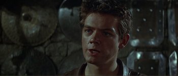 Movie still from “The Masque of the Red Death” (1964), directed by Roger Corman – A person wearing a suit and tie; Close Up shot, Over the shoulder angle