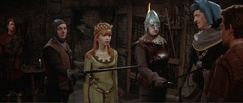 Movie still from “The Masque of the Red Death” (1964), directed by Roger Corman – A woman in a medieval dress and a man in a suit of armor; Medium shot, High angle