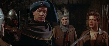 Movie still from “The Masque of the Red Death” (1964), directed by Roger Corman – Two men dressed in medieval costumes in front of a stone wall; Medium shot, Over the shoulder angle