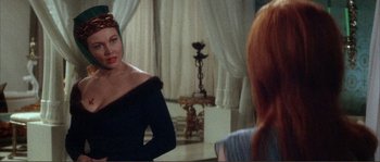 Movie still from “The Masque of the Red Death” (1964), directed by Roger Corman – A woman in a black dress looking in the mirror; Close Up shot, Over the shoulder angle