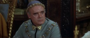 Movie still from “The Masque of the Red Death” (1964), directed by Roger Corman – A person wearing a suit and a bow tie; Close Up shot, High angle