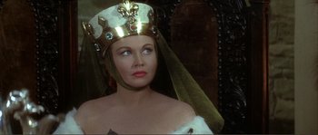 Movie still from “The Masque of the Red Death” (1964), directed by Roger Corman – A woman wearing a gold crown and a white dress; Close Up shot, Over the shoulder angle