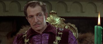 Movie still from “The Masque of the Red Death” (1964), directed by Roger Corman – A person sitting in a chair wearing a suit; Close Up shot, Over the shoulder angle