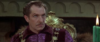 Movie still from “The Masque of the Red Death” (1964), directed by Roger Corman – A man wearing a purple robe and a gold necklace; Close Up shot, Over the shoulder angle